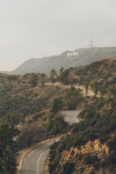 an empty road in the middle of a hilly area