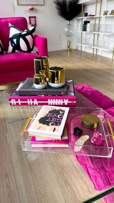 a living room with pink couches and gold accessories on the coffee table in front of it