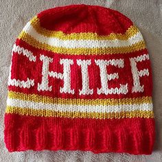 a red and white knitted hat with the word chief on it's side