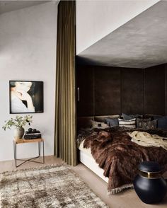 a bedroom with a bed, rug and pictures on the wall