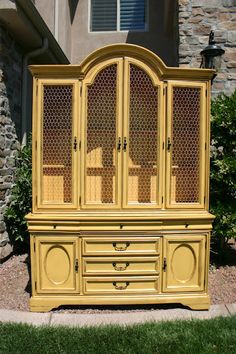 a yellow china cabinet sitting in front of a house