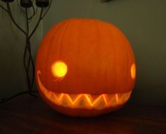 a carved pumpkin sitting on top of a wooden table