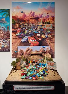 two pictures of cars on display in a room with white walls and black flooring