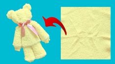 a teddy bear with a pink ribbon on it's neck next to a towel