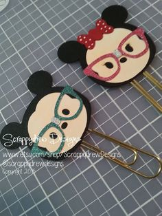 two mickey mouse hair clips with glasses on them