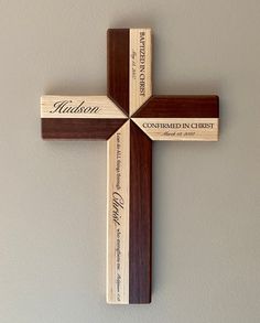 a wooden cross hanging on the wall with two names engraved on it and an inscription that reads, madison combined in christ