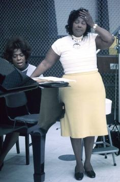 a woman standing in front of a piano