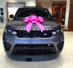 a grey car with a pink bow on it's hood and the caption is in spanish