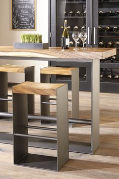 a kitchen table with stools and wine bottles