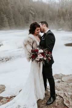 a man and woman standing next to each other on top of a snow covered field