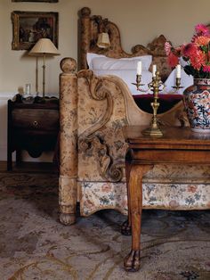 a bedroom with a bed, table and flowers on it