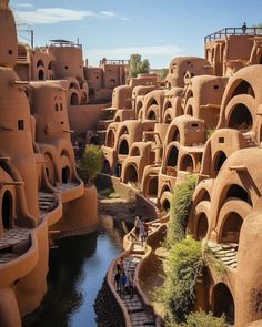 people are standing on the edge of an area made out of clay buildings and water