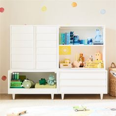 a white book shelf with books and toys on it in a child's room