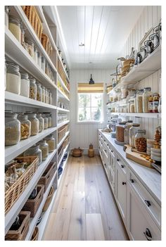 a kitchen filled with lots of white shelves and baskets on top of it's sides