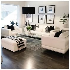 a living room with white furniture and black accents