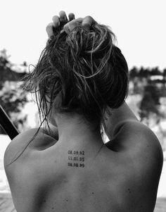 the back of a woman's neck with tattoos on it