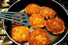 some food is cooking in a frying pan on the stove top with a spatula