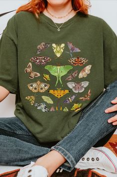 Embrace the whimsical beauty of nature with this Comfort Colors Luna Moth Shirt. Perfect for those in love with the vintage cottagecore aesthetic, this boho moth t-shirt is a charming addition to your summer wardrobe. Casual Green Top With Butterfly Print, Green Tops With Plant Print For Fall, Green Botanical Graphic Print Tops, Botanical Graphic Print Green Tops, Nature-inspired Green Cotton T-shirt, Green Nature-inspired Cotton T-shirt, Green Cotton Nature-inspired T-shirt, Green Botanical T-shirt With Graphic Print, Botanical Green T-shirt With Graphic Print