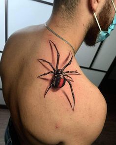 a spider tattoo on the back of a man's upper half - arm and chest