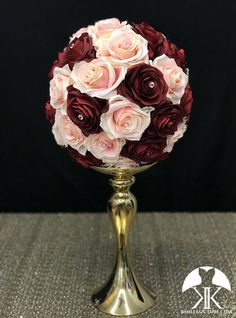 a gold vase filled with pink and red flowers