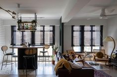 a living room filled with furniture and lots of windows next to a kitchen counter top