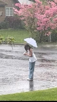 a woman standing in the rain with an umbrella