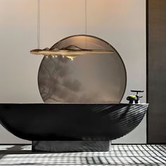 a black bath tub sitting next to a round mirror