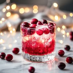 cranberry cocktail in a glass with ice and garnish on the table