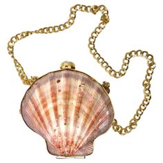 A retro gem from the 1970's! This beautiful seashell bag really leans into the era by making this statement vibrant gold shoulder bag. It is super chunky in shape but has a simple design that balances beautifully. Create the most stunning ensemble by adding just the most perfect accessories. This bag has a whole seashell as it's body that measures 6 inches in height and 5.5 inches in length and a chain length of of 14 inches. This would be a perfect addition to your resort wear to bring on your Seashell Bag, Louis Vuitton Heels, Gold Shoulder Bag, Mermaid Bag, Shell Purse, Money Purse, Gold Chanel, Crochet Purse Patterns, Gold Bag