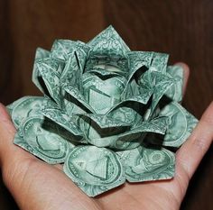 a person holding money origami in their hand