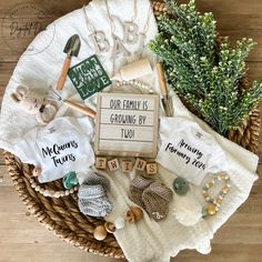 a basket filled with personalized baby clothes and toys on top of a wooden floor