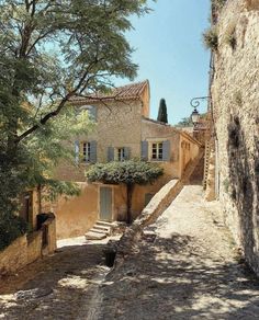 an old stone building with blue shutters on the windows and steps leading up to it