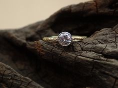 a diamond ring sitting on top of a piece of wood