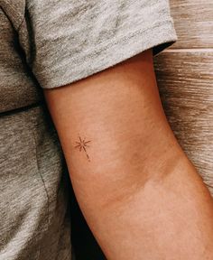 a person with a small star tattoo on their arm