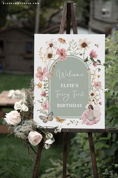 an easel with a sign that says welcome eliie's first birthday