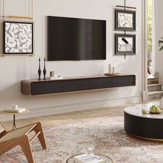 a modern living room with white walls and wood furniture, including a large flat screen tv mounted on the wall