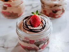 three jars filled with desserts sitting on top of a table