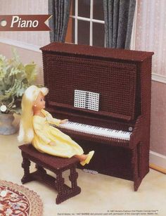 a doll sitting on a bench next to a piano