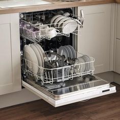 an open dishwasher in a kitchen with white cabinets and wood flooring on the side