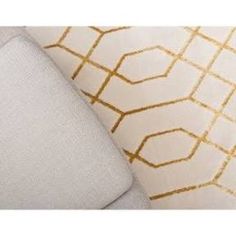 an upholstered white and gold patterned pillow