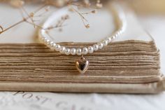 This delicate pearl necklace features freshwater pearls and a 14k gold-filled mini heart charm (won't tarnish). The perfect blend of elegance and charm. Materials: freshwater pearls, 14k gold-filled extender and hardware Dimensions: 14 inches with 3-inch extender This piece is waterproof; if it gets wet, it will not tarnish. What is 14k gold-filled? Waterproof (won’t tarnish) Hypoallergenic (ideal for sensitive skin) Most affordable gold option The technical answer:Brass is bonded with a 5% laye Cheap Heart-shaped Necklace With Pearl Charm, Pearl Necklace With Heart, Small Pearl Necklace, Necklace With Heart, Mini Heart, Heart Charm, Freshwater Pearls, Sensitive Skin, Gold Filled