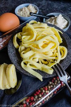 some food that is on a plate with spoons and eggs in the back ground