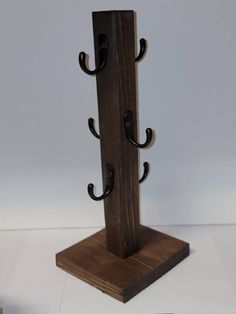 the coat rack is made out of wood and has three hooks on each hooks