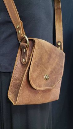 "Handcrafted Leather shoulder purse! Created from top grain cowhide. This beautiful brown leather shoulder bag is rustic yet rugged. The bag itself is 7\" high x 7\" wide by 3\" deep, a perfect size for a quick outing with its adjustable shoulder strap! Handcrafted by me in my NC studio and finished with stylish brass rivets and a lock closure. Hand sewn. Everything hand done by me in my North Carolina studio." Rustic Leather Shoulder Bag For Everyday Use, Rustic Handmade Shoulder Bag For Everyday Use, Rugged Brown Shoulder Bag For Everyday, Rugged Brown Shoulder Bag For Everyday Carry, Handmade Rustic Shoulder Bag For Everyday Use, Rustic Leather Crossbody Bag, Handmade Rustic Brown Shoulder Bag, Vintage Hand-tooled Crossbody Shoulder Bag, Artisan Hand-tooled Crossbody Satchel