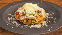 a black plate topped with food on top of a wooden table