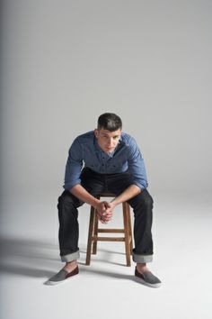 a man sitting on top of a wooden stool