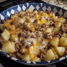 a blue and white bowl filled with food on top of a stove