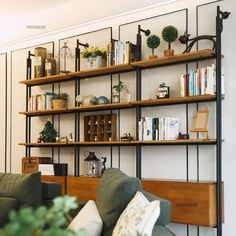 a living room filled with furniture and bookshelves covered in lots of shelves next to a green couch