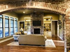 a living room with brick walls and wood flooring is pictured in this image from the inside