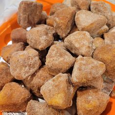 a plate full of sugared donuts sitting on top of an orange plastic container